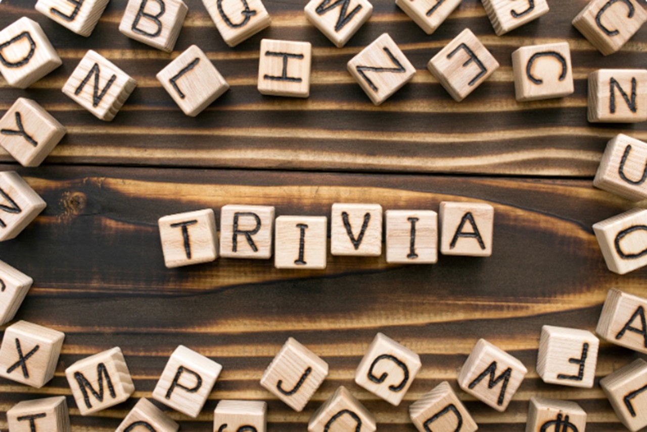 Wooden blocks spelling out the word "trivia" sitting on a wooden table.